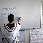 Leena writing in Inuktitut (syllabic) on a white board in a classroom of the Pirurvik Centre.