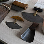 Inuit tools laying on a table, including, various ulus, the traditional Inuit knives.