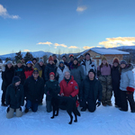 Les participants rassemblés sur la neige, avec une chaîne de montagnes en arrière-plan.