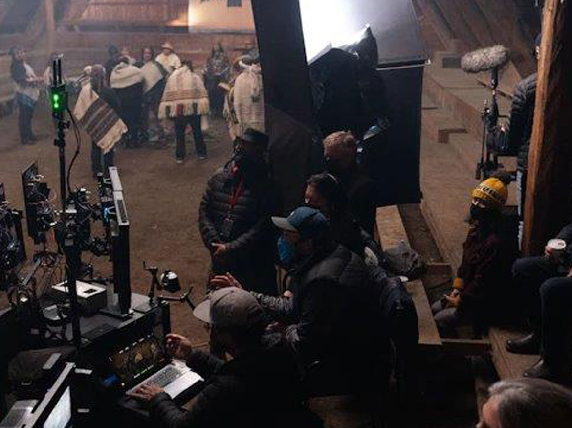 Film crew on set operating camera and lighting equipment.