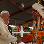 À côté de l'ancien chef de la Nation crie Ermineskin, le pape François serre la main de l'ancien chef de la Nation crie Samson.