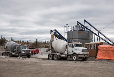 The picture shows cement trucks at the concrete batch plant at Giant Mine.